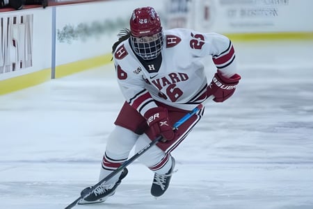 Ein Eishockeyspieler der Ontario Hockey Academy in weißer Uniform läuft auf der Eisbahn in der Sportarena.