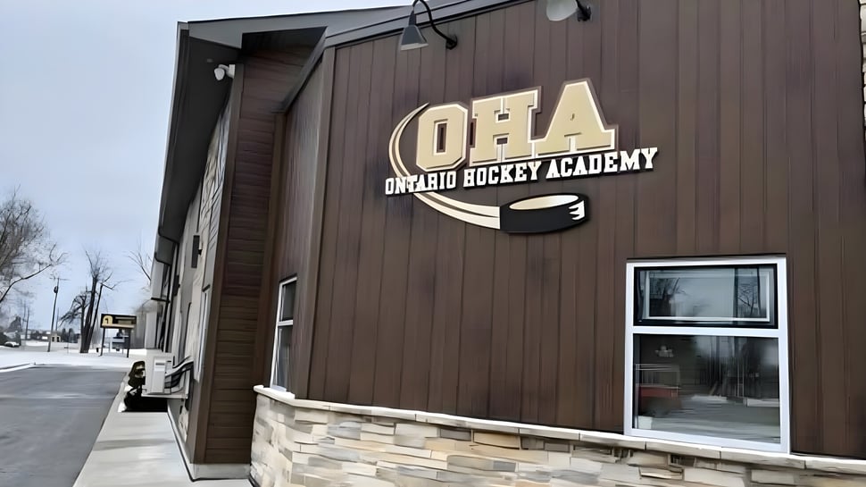 Das Gebäude der Ontario Hockey Academy mit Holzverkleidung und dem Logo auf der Frontseite ist zu sehen.