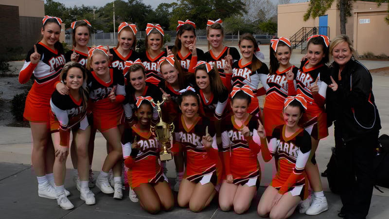 Schülerinnen der Orange County Public Schools posieren mit einem Pokal vor einem Gebäude.