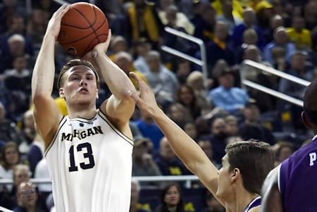 Ein Basketballspieler der Orangeville District Secondary School springt zum Korb während Zuschauer im Hintergrund zu sehen sind.