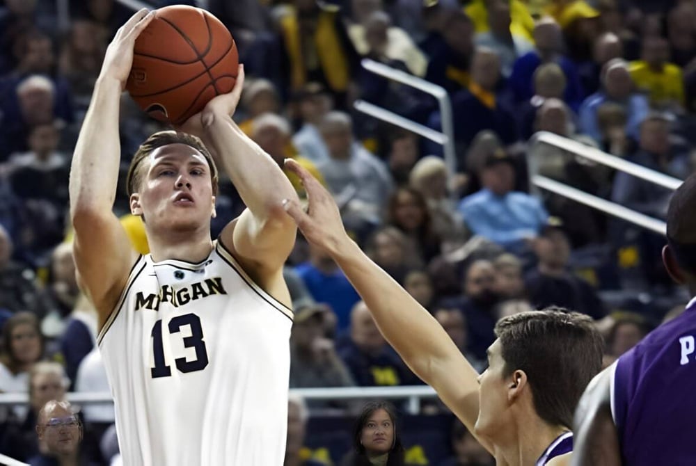 Ein Basketballspieler der Orangeville District Secondary School springt zum Korb während Zuschauer im Hintergrund zu sehen sind.