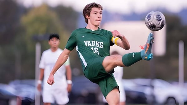 Ein Schüler der Oregon Episcopal School tritt einen Fußball auf dem Sportplatz während eines Spiels.