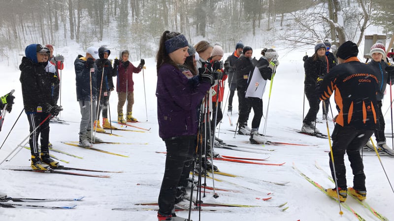 Eine Gruppe von Schülerinnen und Schülern der Orillia Secondary School steht auf Skiern in einem verschneiten Wald.