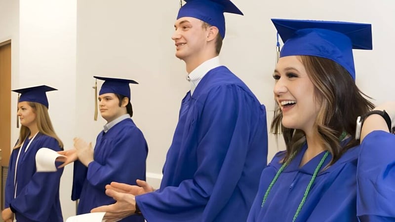 Eine Gruppe von Absolventinnen und Absolventen der Ormeau Woods State High School steht gemeinsam im Flur in blauer Kleidung mit Hüten.