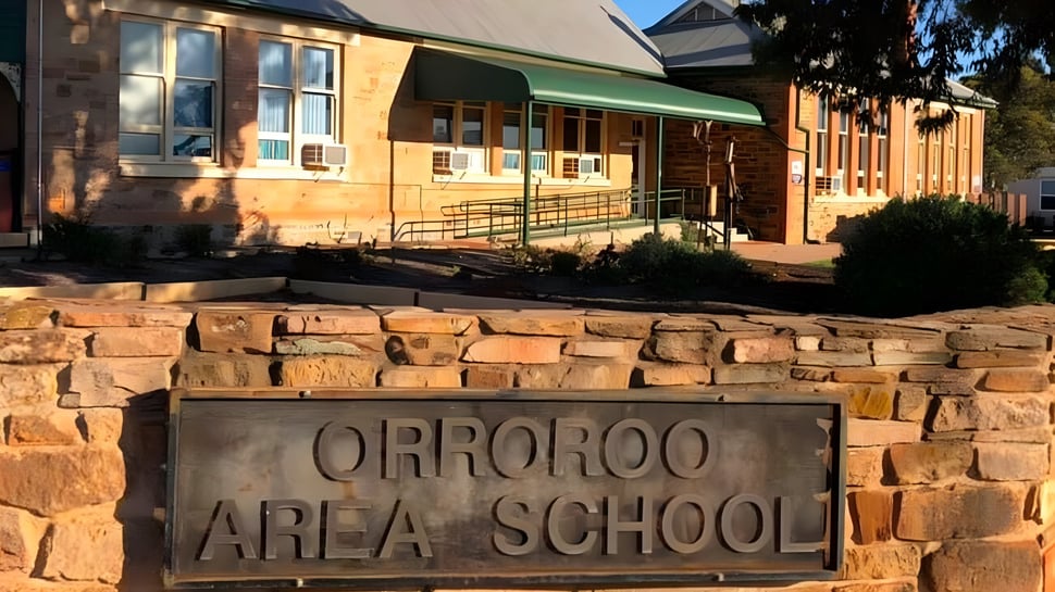 Das Eingangsschild der Orroroo Area School steht vor einem Backsteingebäude und Bäumen im Hintergrund.