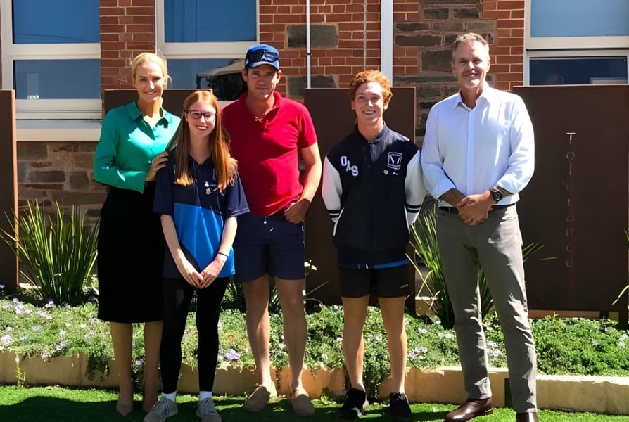 Eine Gruppe von fünf Personen steht vor dem Backsteingebäude mit blauen Fenstern auf dem Campus der Orroroo Area School.