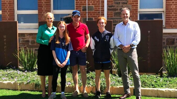 Eine Gruppe von fünf Personen steht vor einem Backsteingebäude mit blauen Fenstern auf dem Gelände der Orroroo Area School.