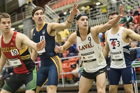 Männliche Athleten der Ottawa Technical Secondary School treten bei einem Basketballspiel vor Publikum an.