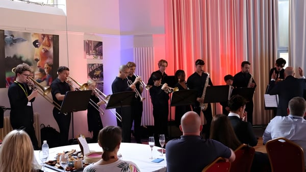 Schüler der Oundle School führen einen Bühnenauftritt in einem festlich geschmückten Saal vor einem Publikum auf.