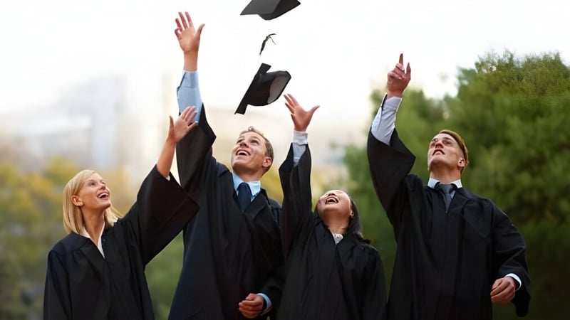 Absolventen der Our Lady of the Rockies High School werfen ihre schwarzen Hüte während der Abschlussfeier in die Luft.