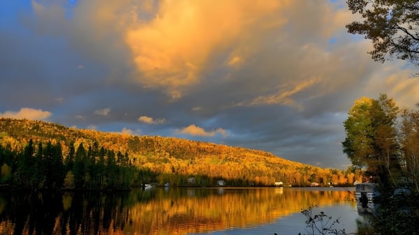Ein ruhiger See mit herbstlicher Laubfärbung unter bewölktem Himmel in der Nähe der Our Lady of the Rockies High School.