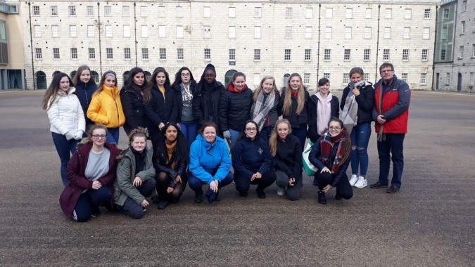 Eine Gruppe Schülerinnen und Schüler steht vor dem grossen mehrstöckigen Gebäude des Our Lady's College.