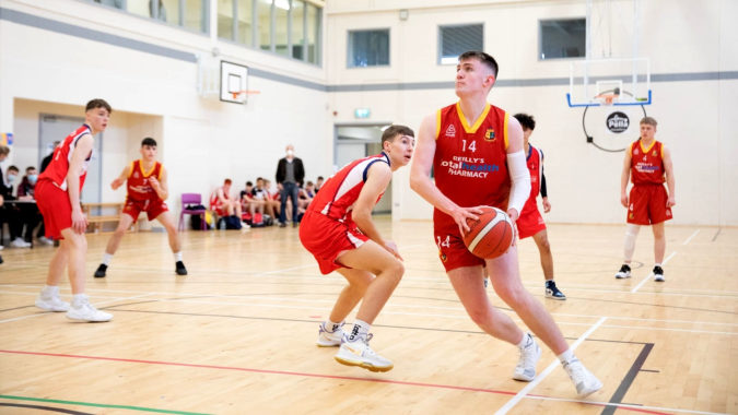 Eine Gruppe Basketballspielerinnen und Spieler der Our Lady’s Secondary School spielt in der Sporthalle ein Basketballspiel.