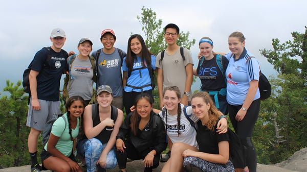 Eine Gruppe Schülerinnen und Schüler der Our Lady’s Secondary School posiert gemeinsam im Freien vor Bäumen und klarem Himmel.