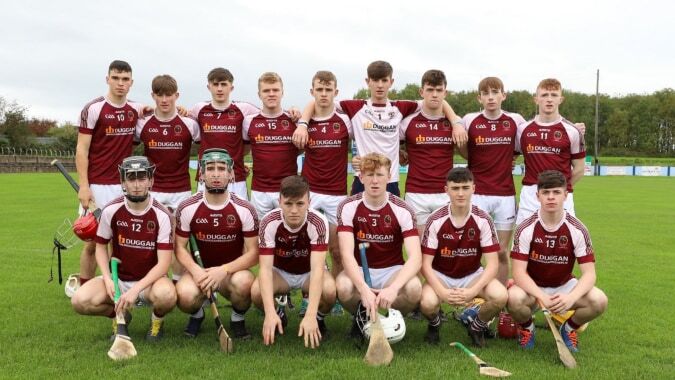 Eine Gruppe Schülerinnen und Schüler der Our Lady’s Secondary School steht im roten und weißen Sportdress auf einem Sportplatz.