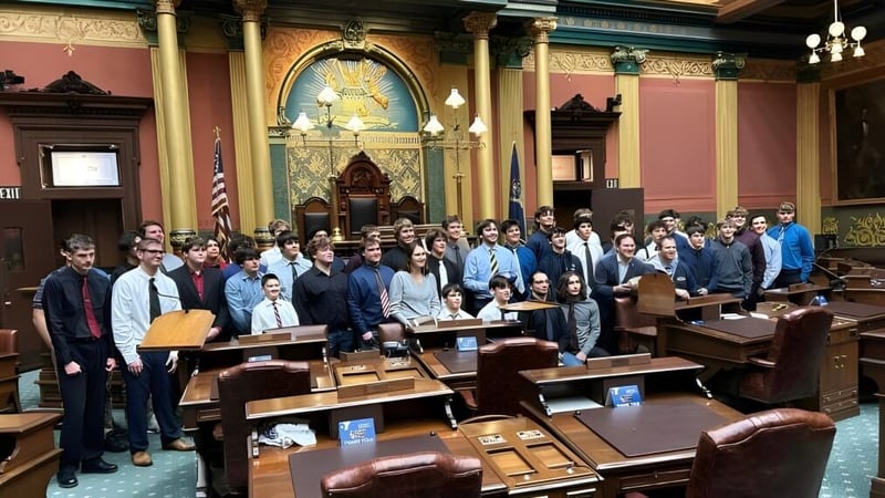 Schüler der Ovid-Elsie High School versammeln sich in einem historischen Gerichtssaal mit kunstvollen architektonischen Details.