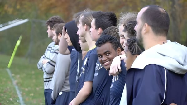 Schüler der Oxford Academy stehen gemeinsam auf einer Wiese mit unscharfem Hintergrund.