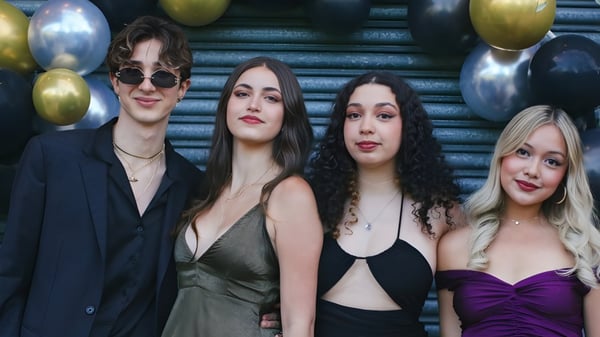 Vier Personen, zwei Frauen und zwei Männer, posieren vor bunten Luftballons am Oxford Sixth Form College.