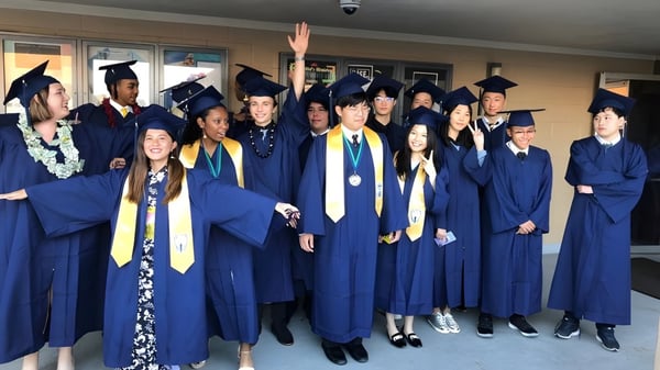 Eine Gruppe von Absolventinnen und Absolventen der Pacific Lutheran High School feiert gemeinsam ihren Abschluss im Flur.