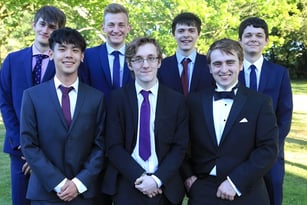 Eine Gruppe von Schülern des Padworth College steht in formeller Kleidung auf einer Wiese mit Bäumen im Hintergrund.