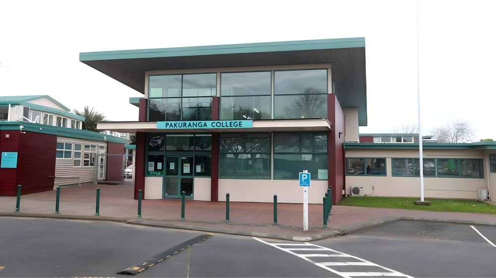 Das moderne mehrstöckige Gebäude mit großen Fenstern auf dem Campus des Pakuranga College mit einem Parkplatz im Vordergrund.