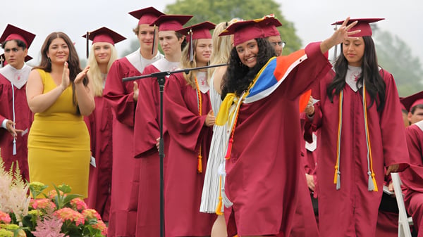 Eine Gruppe von Absolventinnen und Absolventen der Palm Beach Currumbin State High School steht vor grünem Pflanzenhintergrund zusammen.