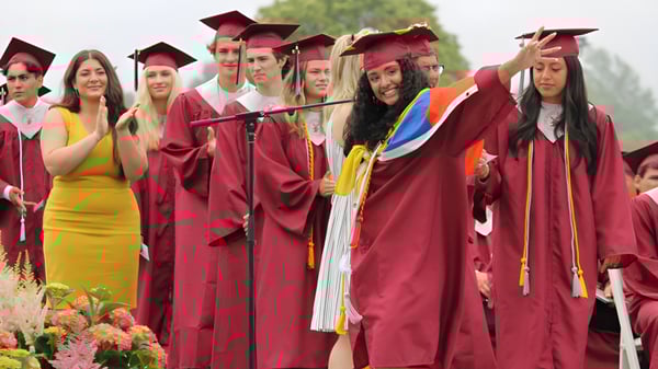 Eine Gruppe von Absolventinnen und Absolventen der Palm Beach Currumbin State High School steht vor grünem Pflanzenhintergrund zusammen.