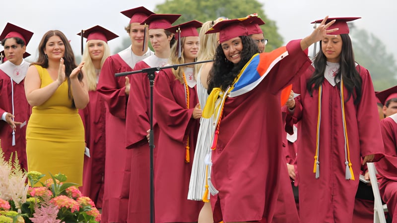 Eine Gruppe von Absolventinnen und Absolventen der Palm Beach Currumbin State High School steht vor grünem Pflanzenhintergrund zusammen.