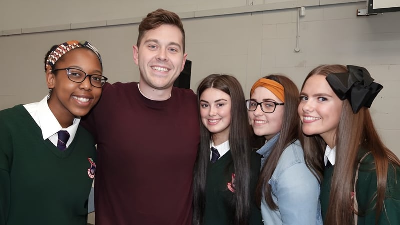 Fünf Schülerinnen und Schüler posieren gemeinsam in der Palmerstown Community School vor einer schlichten Wand.