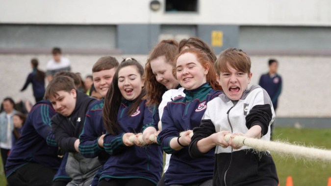 Eine Gruppe von Schülern in Schuluniform steht vor einem Gebäude auf dem Campus der Palmerstown Community School.