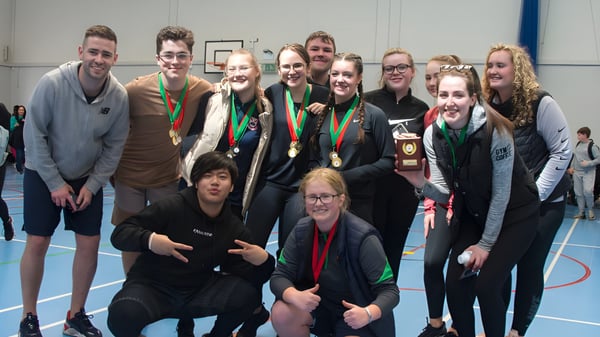 Eine Gruppe von Schülern mit Medaillen posiert in einer Sportanlage der Palmerstown Community School.