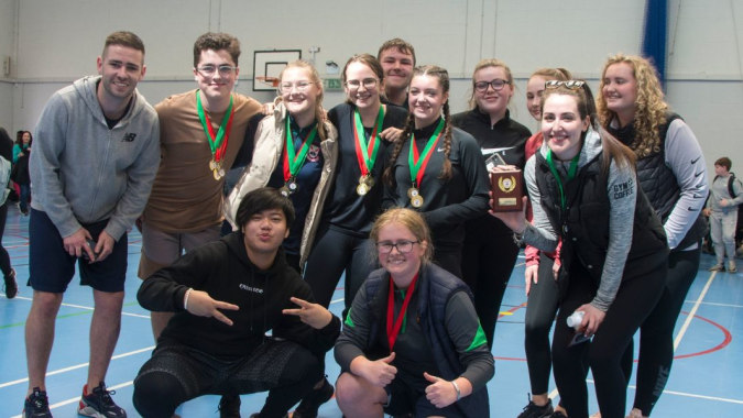 Eine Gruppe von Schülern der Palmerstown Community School posiert mit Medaillen in der Sporthalle.