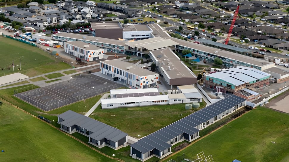 Luftaufnahme des Papamoa College mit mehreren Schulgebäuden und umliegenden Wohngebieten und Grünflächen.
