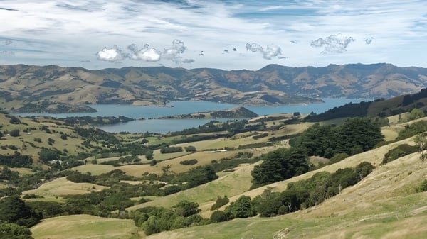 Eine malerische Landschaft mit grünen Hügeln und einem See vor Bergen, nicht direkt auf dem Gelände der Papanui High School.