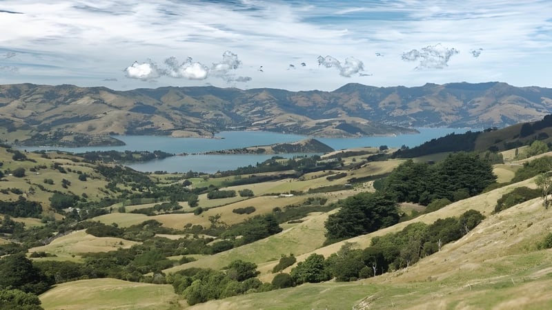 Eine malerische Landschaft mit grünen Hügeln und einem See vor Bergen, nicht direkt auf dem Gelände der Papanui High School.