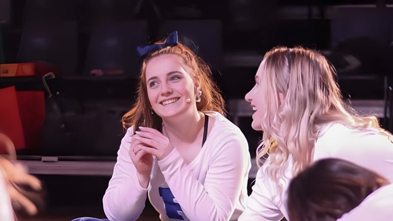 Zwei Schülerinnen der Papanui High School stehen gemeinsam auf einer Bühne vor dunklem Vorhang.