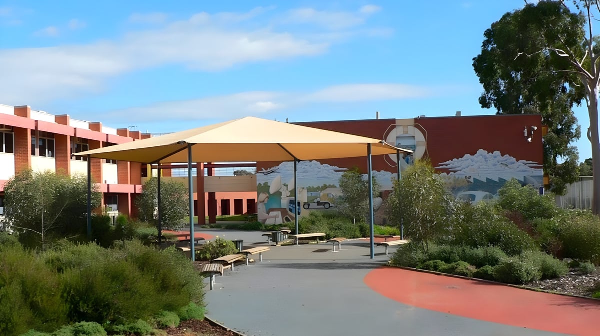 Der bunte Außenbereich mit Sitzgelegenheiten und Sonnenschirmen auf dem Gelände der Paralowie R-12 School.