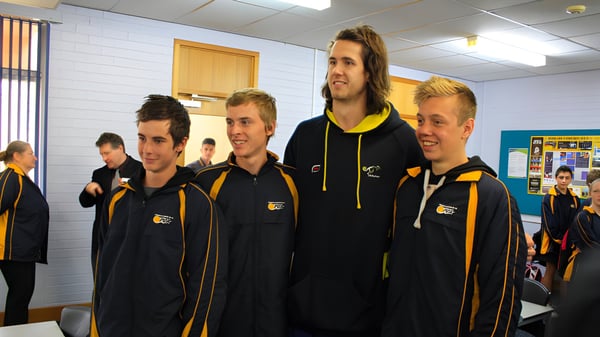 Eine Gruppe von Schülern der Paralowie R-12 School steht in schwarzen und gelben Uniformen in einer Sportanlage.