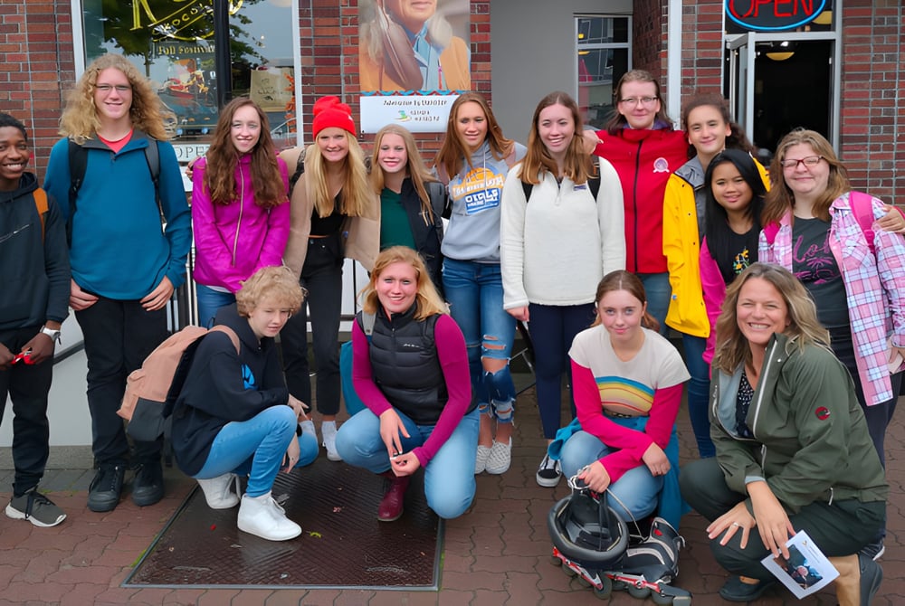 Eine Gruppe von Schülerinnen und Schülern steht auf dem Außengelände der Parkland Secondary School vor einem Backsteingebäude.