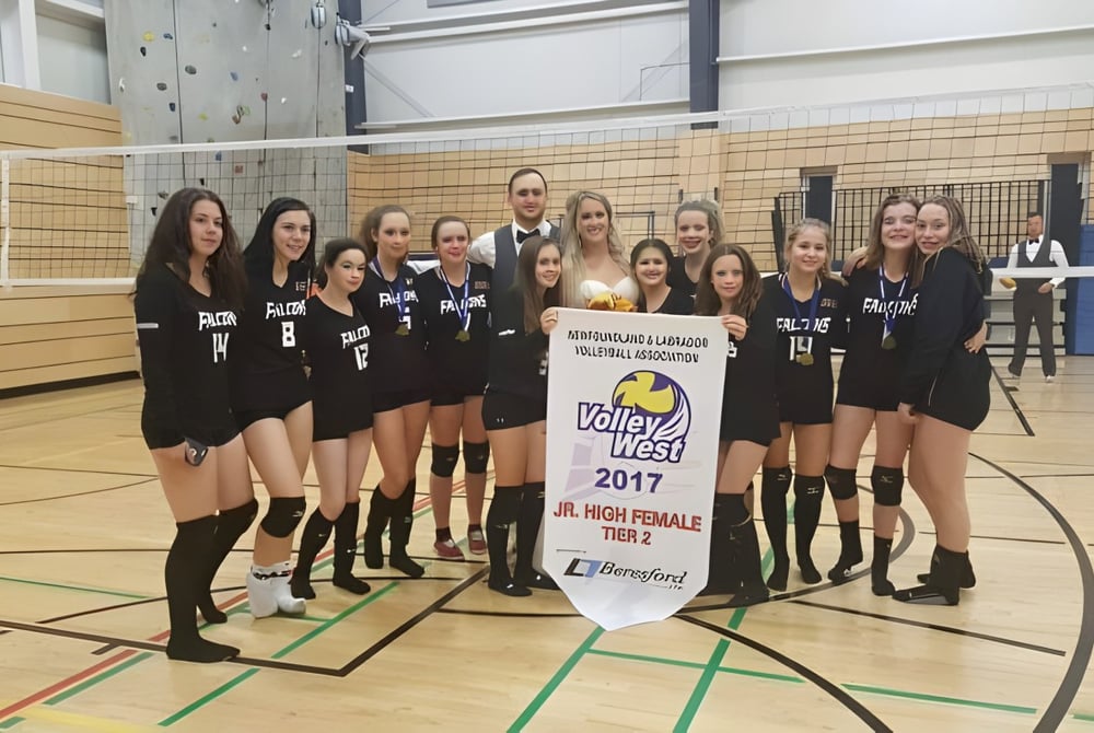 Eine Gruppe weiblicher Volleyballspielerinnen hält ein Meisterschaftsbanner in der Sporthalle der Pasadena Academy.