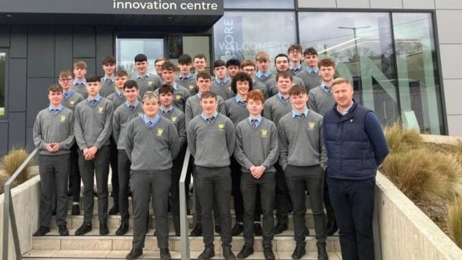Eine Gruppe Schüler in Schuluniform steht vor dem Innovation Centre auf dem Gelände der Patrician High School.