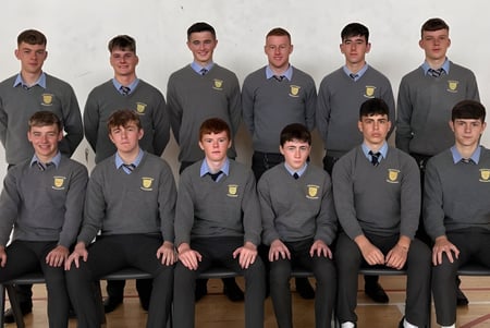 Eine Gruppe von Schülern der Patrician High School posiert in Schuluniform für ein formelles Gruppenfoto vor neutralem Hintergrund.