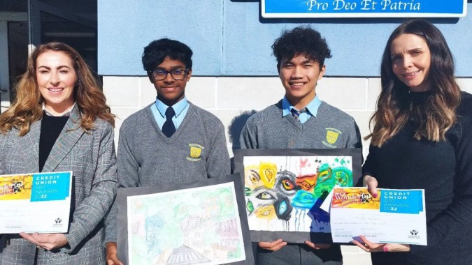 Vier Schülerinnen und Schüler der Patrician High School zeigen gemeinsam ihre bunte Kunst im Schulgebäude.