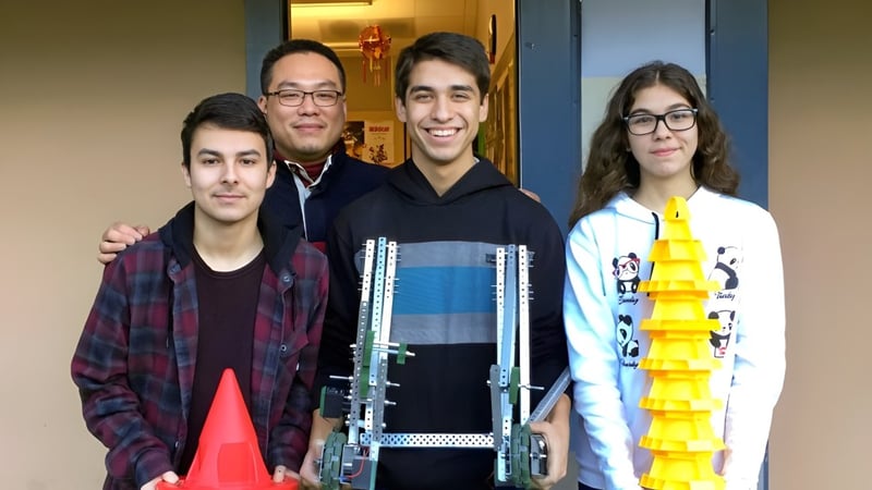 Eine Gruppe von vier Schülerinnen und Schülern steht mit der Pender Harbour Secondary im Flur und lächelt.