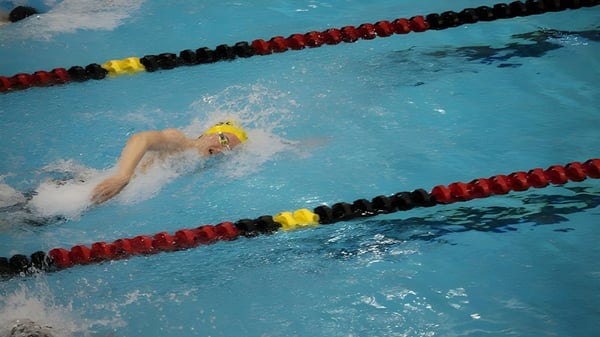 Ein Schwimmer mit gelber Badekappe schwimmt im Wettkampfbecken auf dem Gelände der Penticton Secondary School.