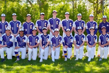 Eine Gruppe von Schülerinnen und Schülern steht auf dem Sportgelände der Peoria Christian School zusammen und bereitet sich auf Baseball vor.