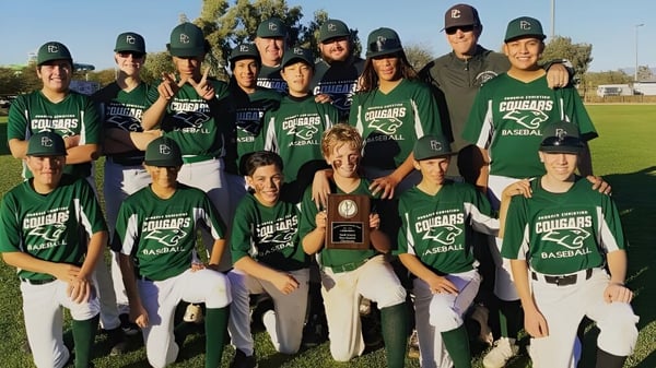 Schüler der Phoenix Christian Preparatory School posieren in grünen Baseball-Uniformen gemeinsam auf dem Baseballfeld.