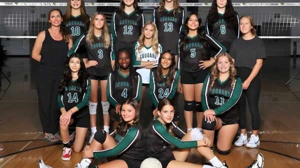 Eine Gruppe junger Volleyballspielerinnen posiert auf dem Volleyballfeld der Phoenix Christian Preparatory School.