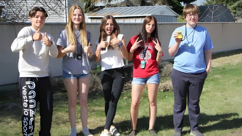 Eine Gruppe von fünf Schülerinnen und Schülern steht auf dem Gelände der Picture Butte High School vor einem Gebäude.