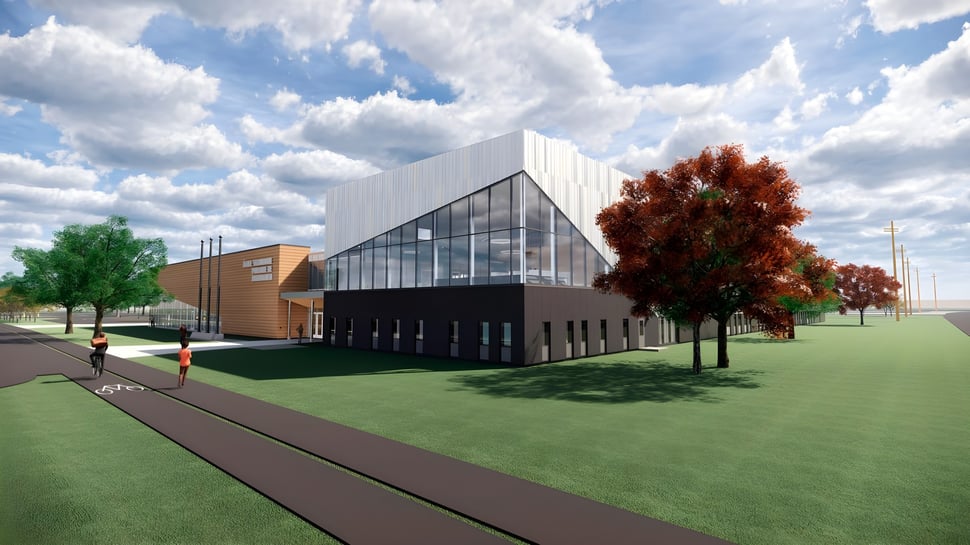 Das moderne Gebäude der École secondaire publique Pierre de Blois steht umgeben von herbstlich gefärbten Bäumen und grünem Gras unter dem bewölkten Himmel.